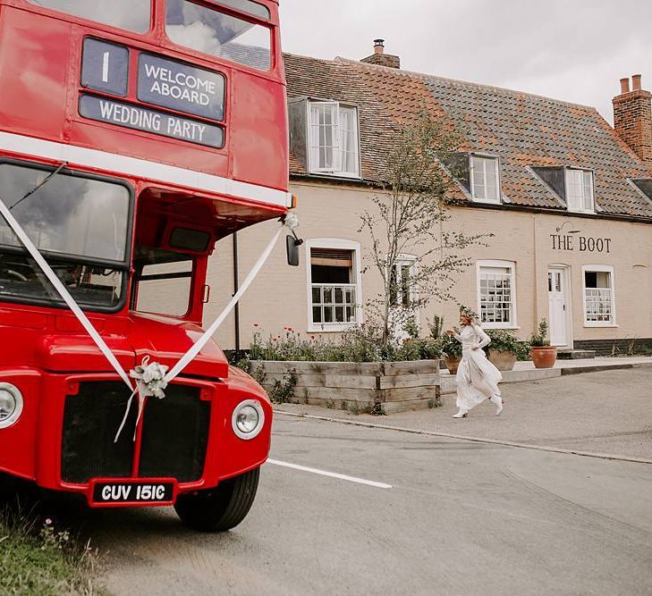 Bride makes her way onto red bus wedding transport