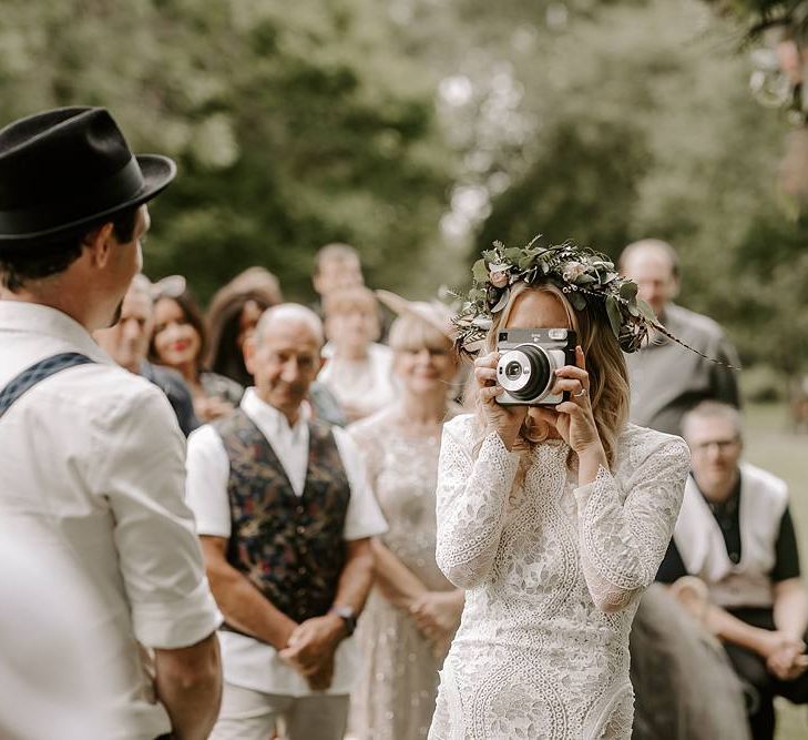 Bride takes a photo of her groom at the altar