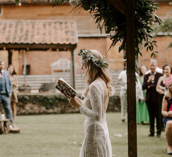 Bride reading her wedding vows during outdoor ceremony