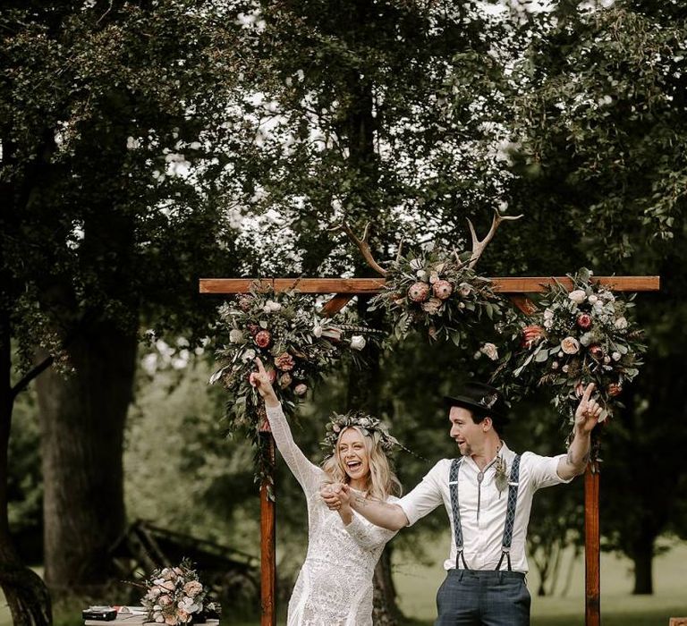 Bride clutching Protea bouquet with new husband celebrating