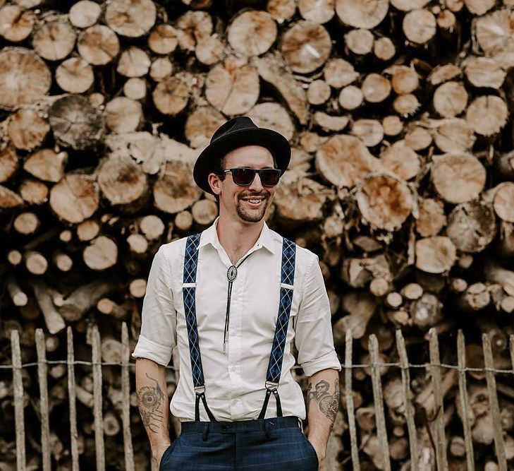 Groom in braces and a hat for boho wedding