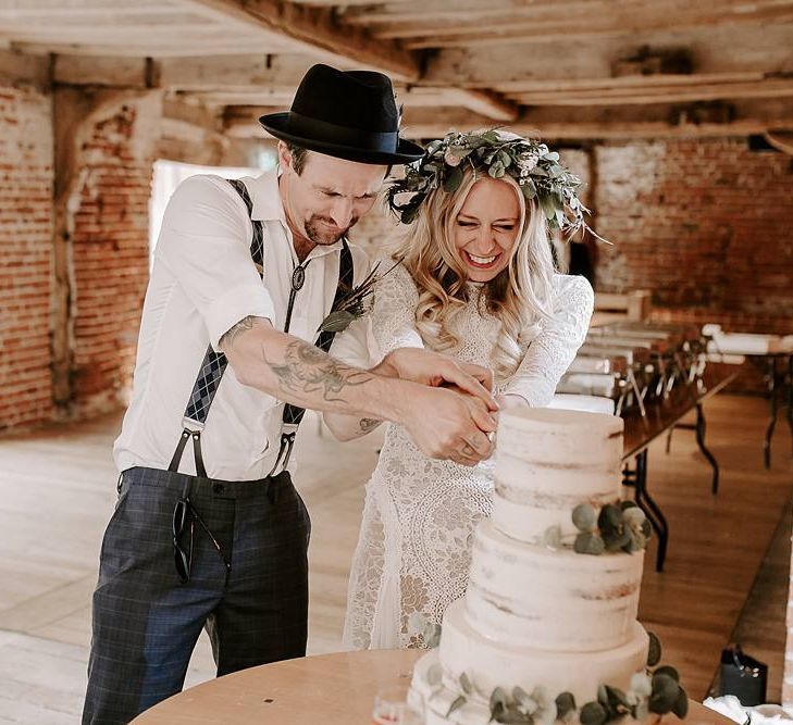 Bride and groom cut the rustic wedding cake