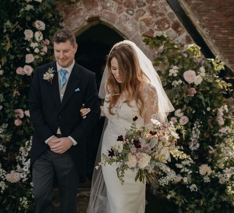 Bride in Lace St Partrick Wedding Dress and Groom in Morning Suit Exiting the Church