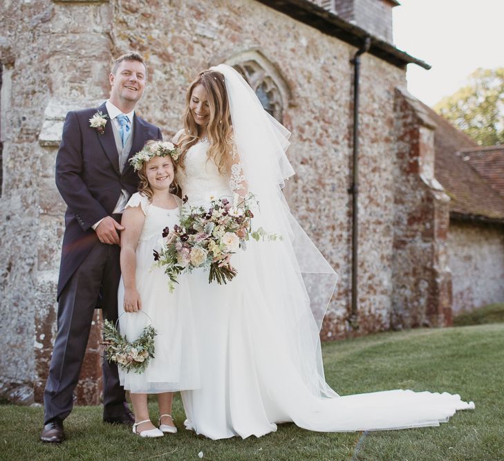 Bride in Lace St Partrick Wedding Dress and Groom in Morning Suit  with Their Flower Girl