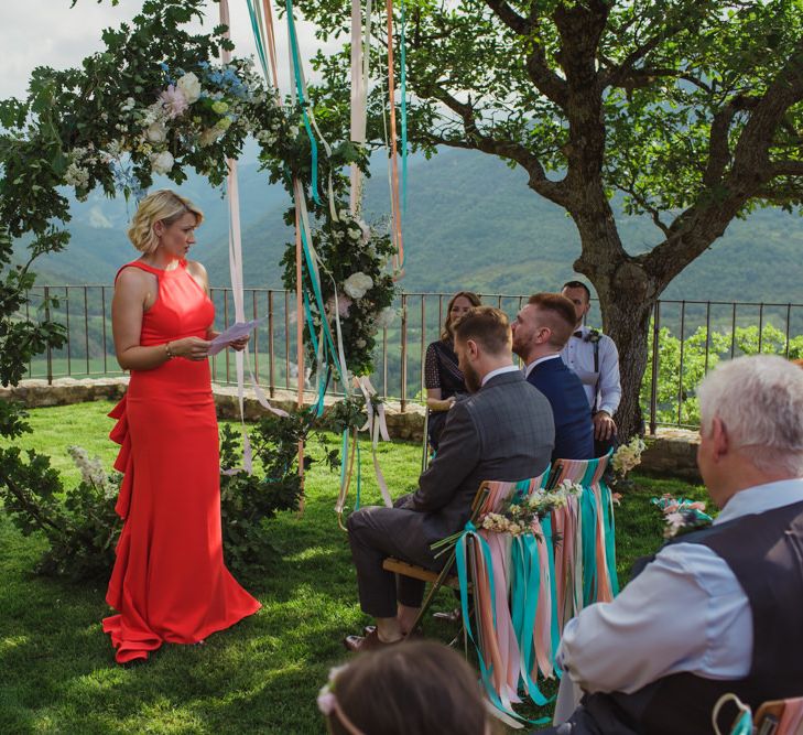 Outdoor Wedding Ceremony with Floral Moon Gate and Chair Back Ribbon Decor