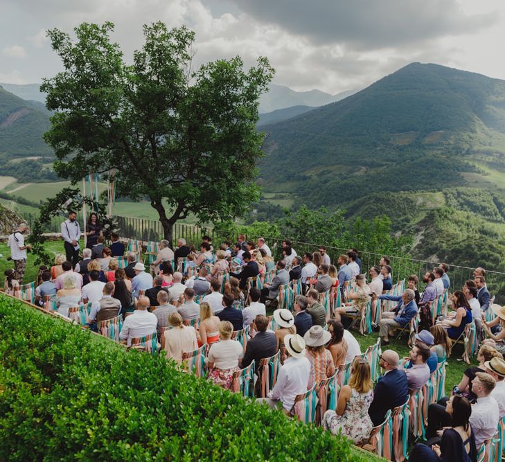 Outdoor Wedding Ceremony at Castello di Naro in Italy with Floral Moon Gate and Ribbon Chair Back Detail