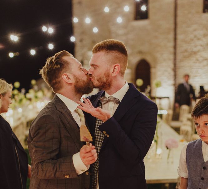 Two Grooms Cutting the Wedding Cake and Kissing