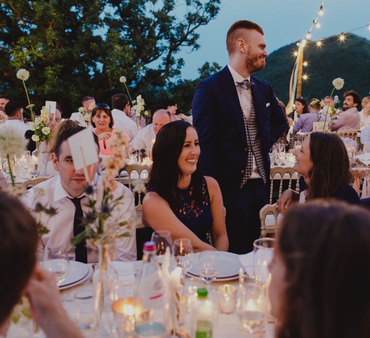 Wedding Guests at Outdoor Wedding Reception with Fairy Lights