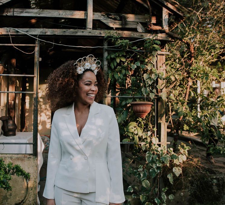 bride wearing a white wedding suit with afro-textured curly hair and ornate bridal crown