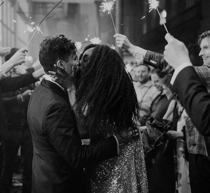 Bride and Groom Kissing Under Sparklers