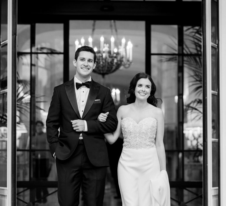 Black and White Portrait of The Bride and Groom Walking Arm in Arm