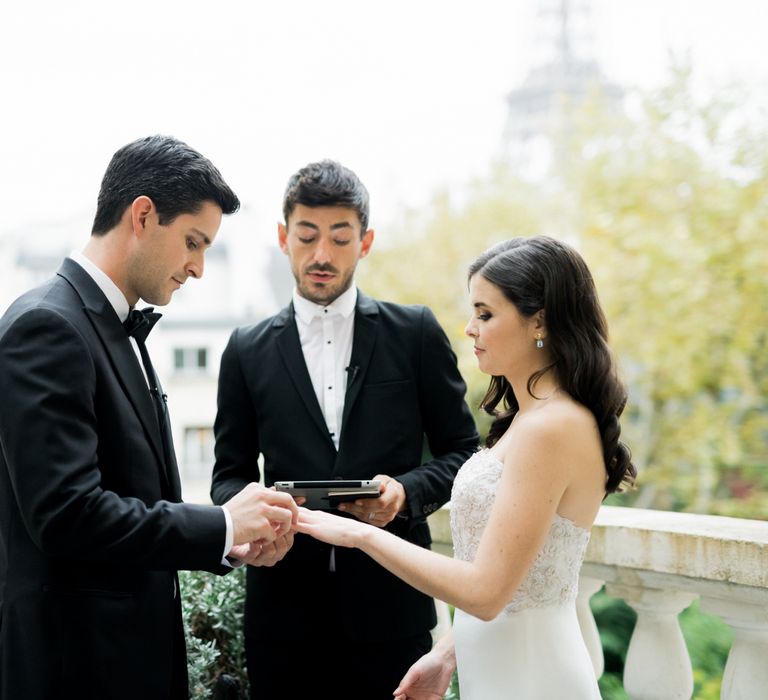 Bride and Groom Exchanging Rings on a Rooftop Terrace with Paris as their Backdrop