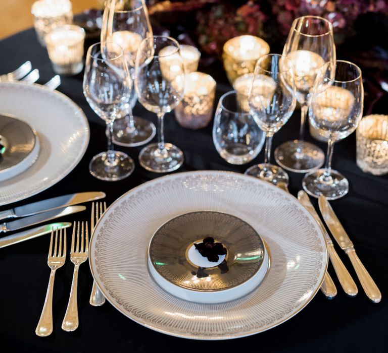 Glamorous Place Setting with Black Table Cloth, White Platter and Candle Light