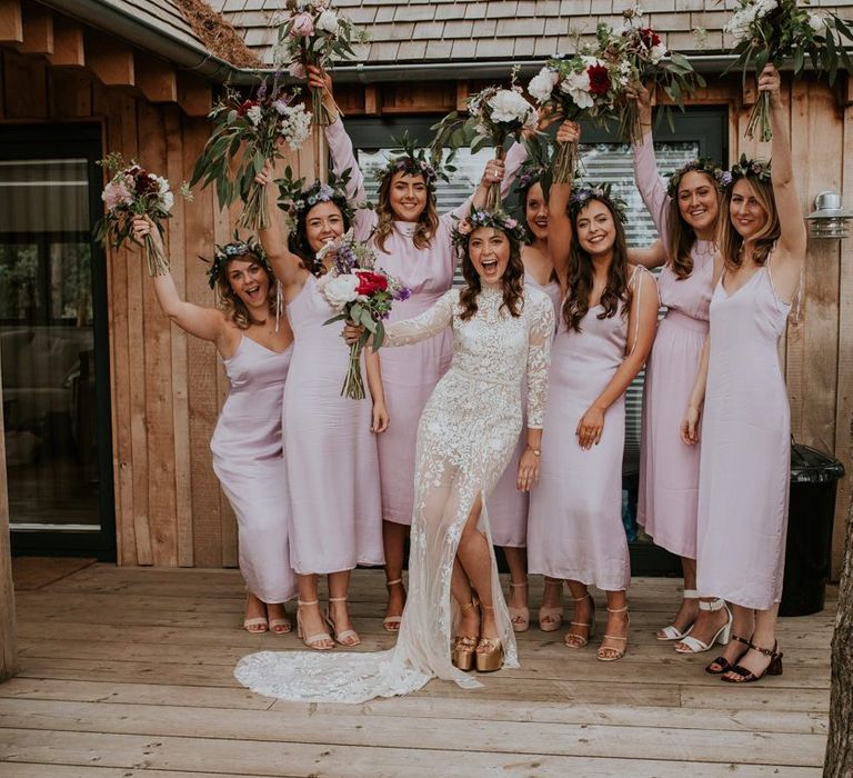 Pink bridesmaid dresses and bride in lace dress with flower crown