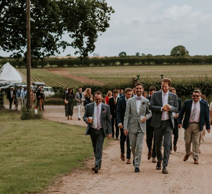 Groom and guests make their way to wedding ceremony