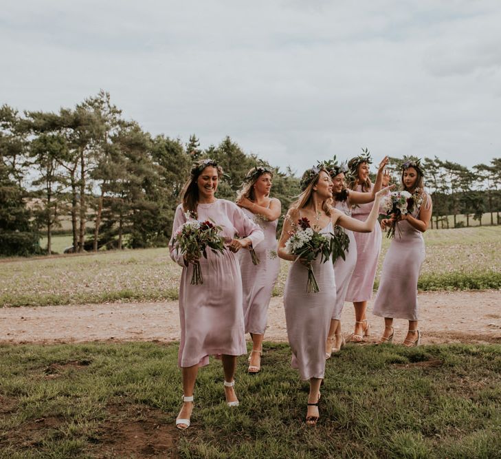 Bridal party on their way to outdoor ceremony at Norfolk wedding venue