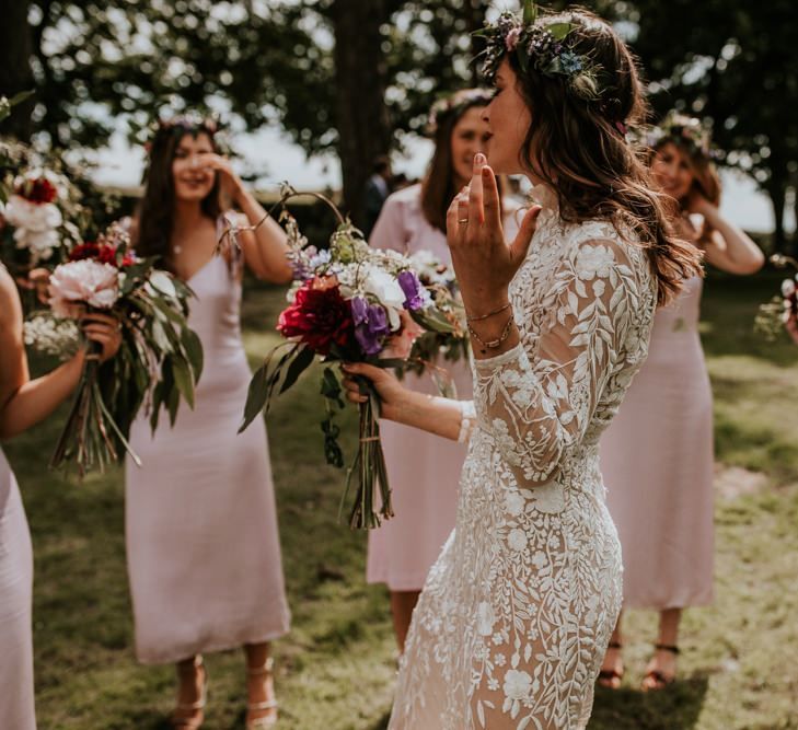 Bride in flower crown and bridesmaids in pink dresses