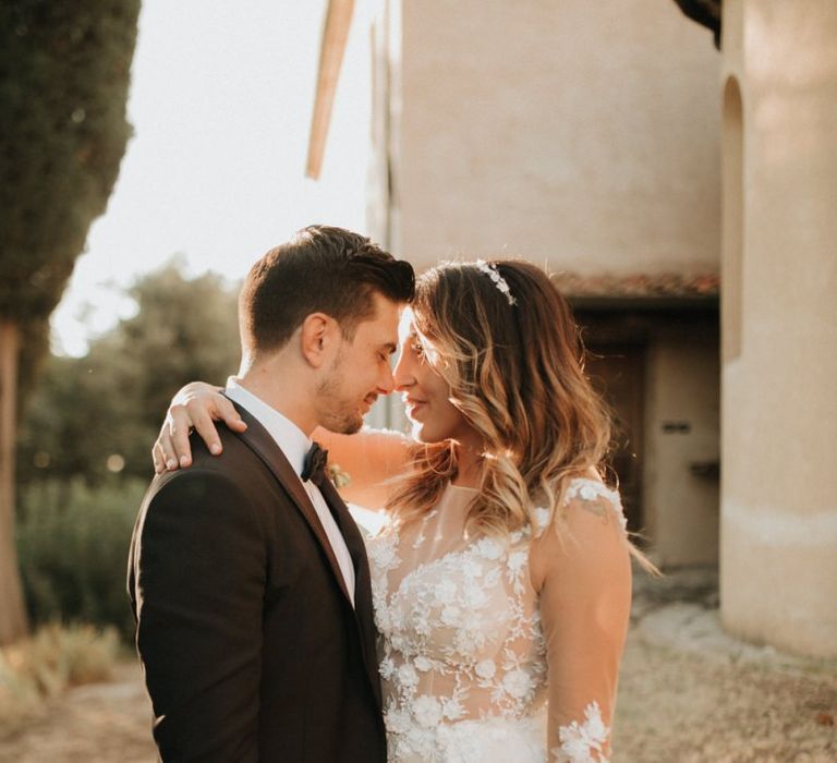 Groom in black tuxedo with bride in appliqué dress with hairband