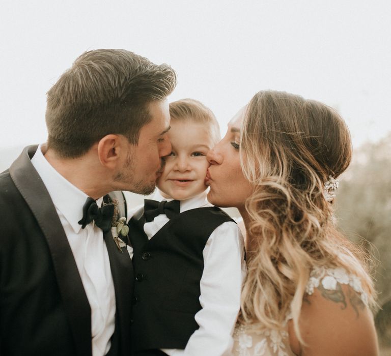 Bride and groom kiss their son at destination wedding