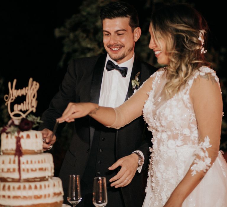 Bride and groom cut the drip wedding cake at destination wedding