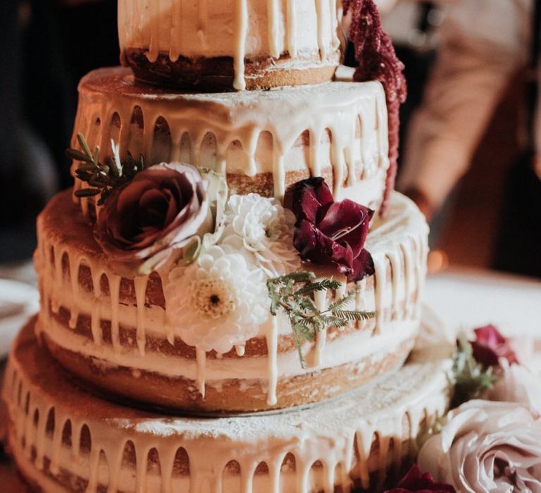 Candle lit drip wedding cake with flower decor