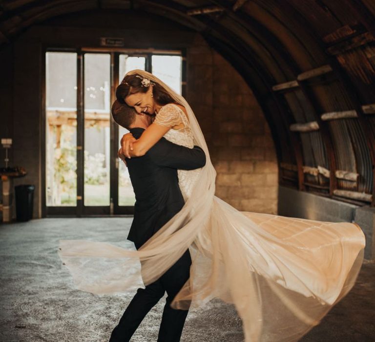 Groom lifts bride in Maggie Sottero wedding dress