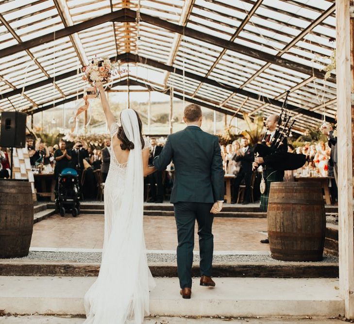 Groom enters reception with bride in Maggie Sottero wedding dress