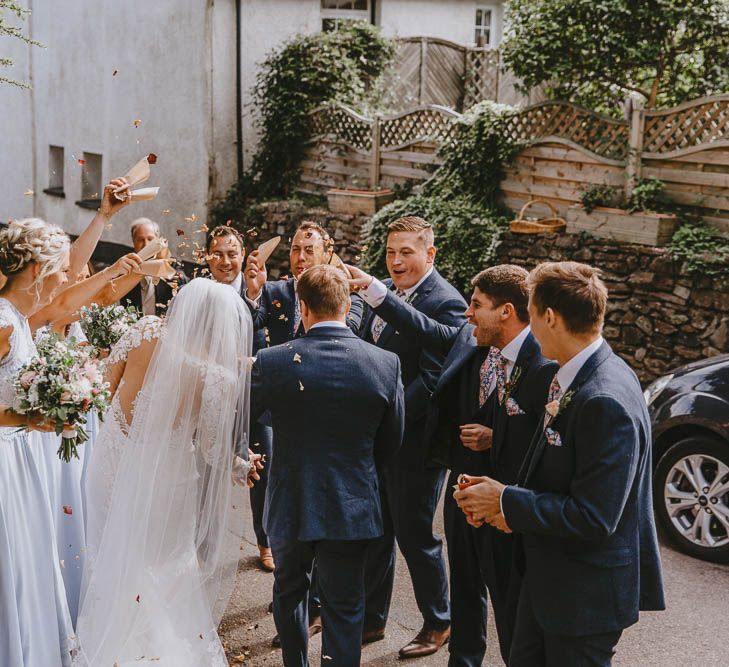 Wedding Party Throwing Confetti Over the Bride and Groom