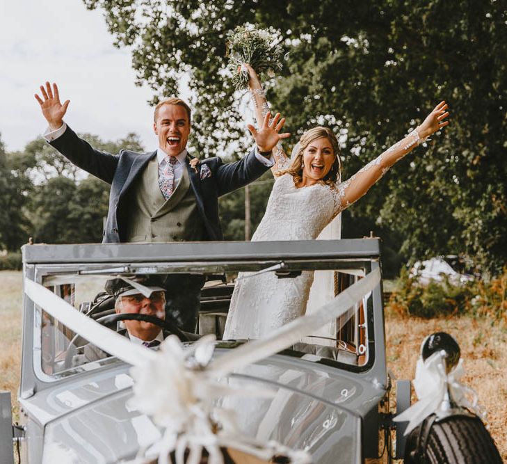 Bride in Lace Sincerity Bridal Wedding Dress And Groom in Blue Ted Baker Suit Standing Up in Their Vintage Wedding Car