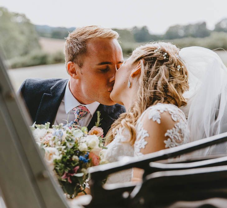 Bride and Groom Kissing in the Back of their Vintage Wedding Car