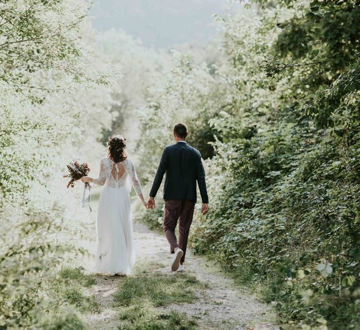 Bride and groom take a stroll through venue grounds