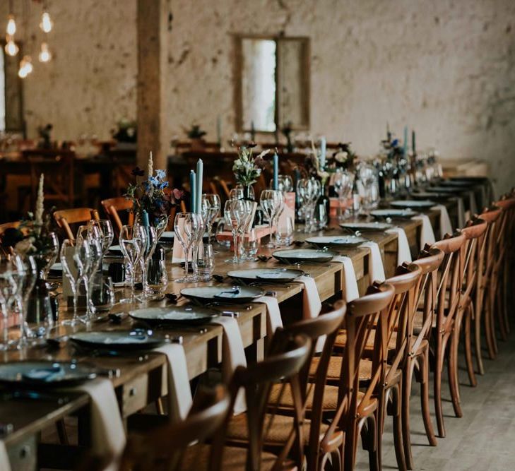 Wooden banquet tables with perspex table plan at French wedding