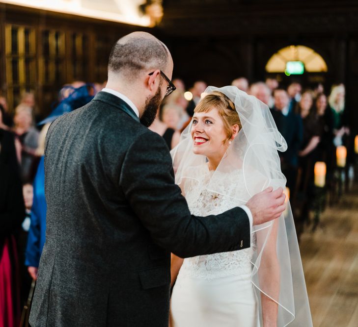 Wedding Ceremony Bride in Lace San Patrick Gown &amp; Veil | Groom in Tweed Chester Barrie Suit | Candle Lit Christmas Wedding at Gray's Inn London with Christmas Carols &amp; Festive Wreaths | John Barwood Photography