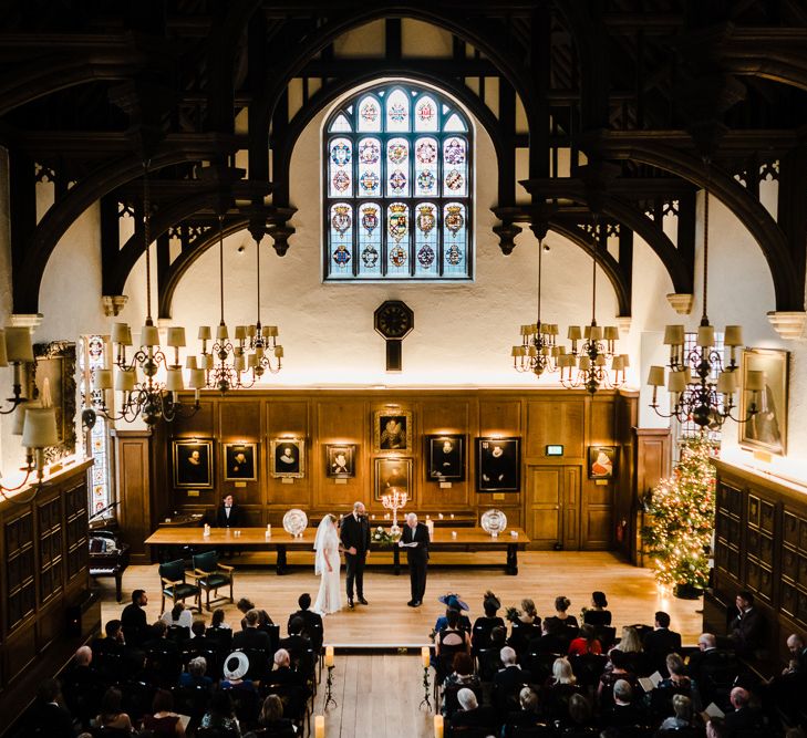 Wedding Ceremony Bride in Lace San Patrick Gown &amp; Veil | Groom in Tweed Chester Barrie Suit | Candle Lit Christmas Wedding at Gray's Inn London with Christmas Carols &amp; Festive Wreaths | John Barwood Photography