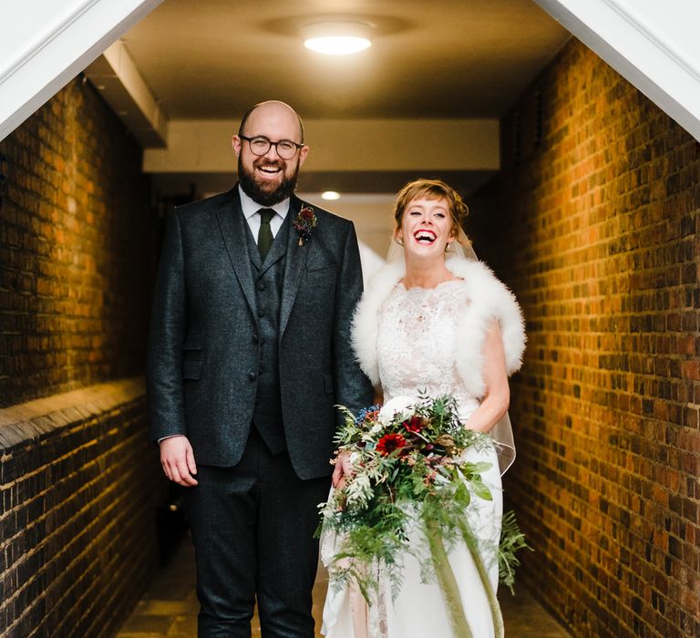 Bride in Lace San Patrick Gown &amp; Fur Coverup | Groom in Tweed Chester Barrie Suit | Candle Lit Christmas Wedding at Gray's Inn London with Christmas Carols &amp; Festive Wreaths | John Barwood Photography