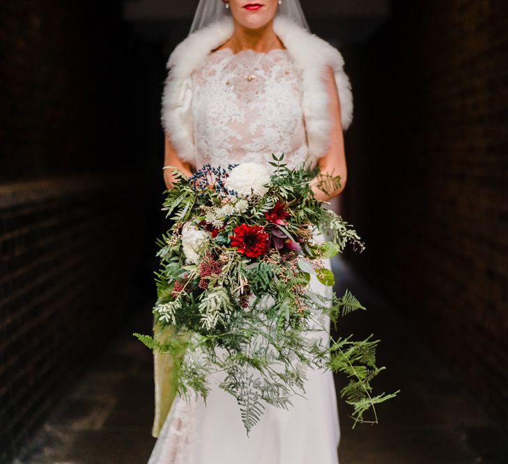 Hand Tied Wedding Bouquet with Foliage, Berries &amp; Blooms | Bride in Lace San Patrick Gown &amp; Fur Coverup | Candle Lit Christmas Wedding at Gray's Inn London with Christmas Carols &amp; Festive Wreaths | John Barwood Photography