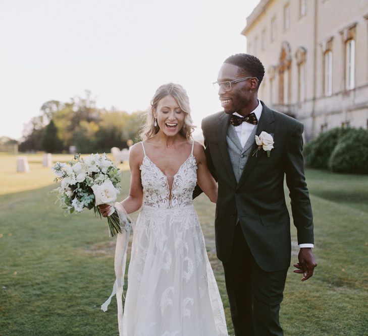 Groom in tuxedo with grey waistcoat and bride in lace wedding dress