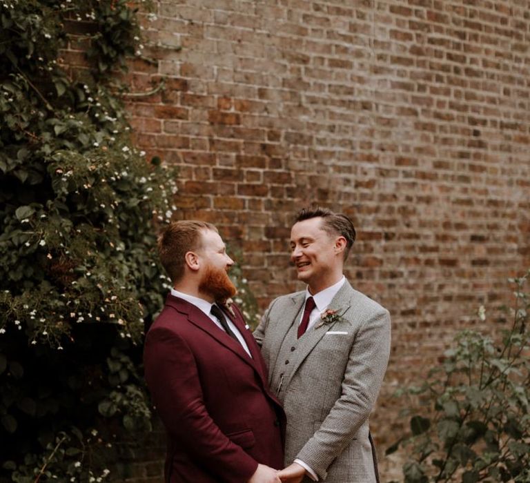 Portrait of groom in burgundy and beige checked suits at their Syon Park wedding