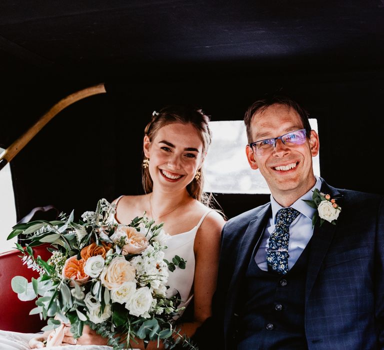 Bride and groom arrival in vintage wedding car