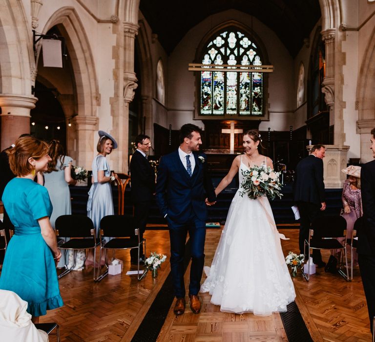 Bride and groom walking up the aisle as husband and wife