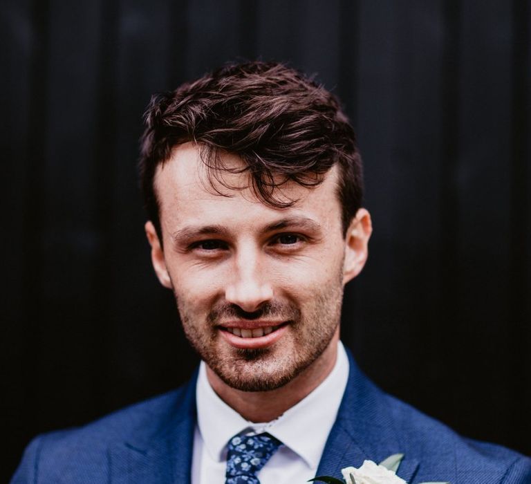 Groom in navy suit with patterned tie