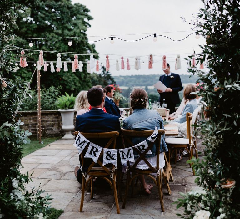 Greenery flower arch, festoon lights and tassels, garden party decor