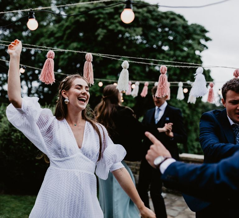 socially distanced wedding reception with festoon lights and tassels