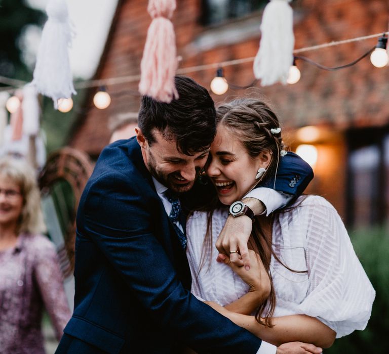 Bride and groom embracing at socially distanced wedding