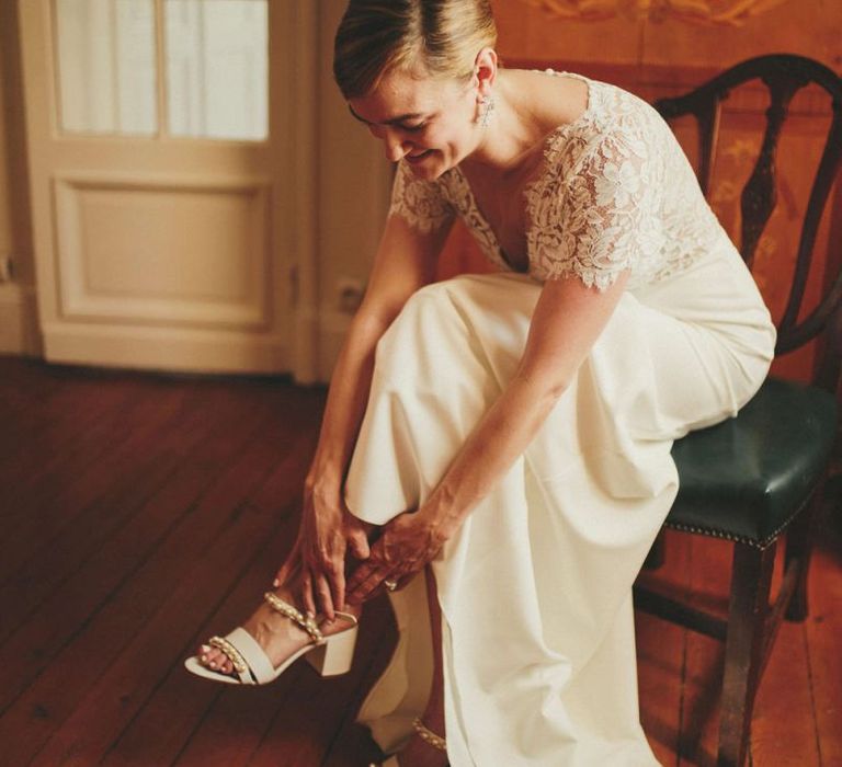 Bride in Sarah Seven dress putting on her wedding shoes