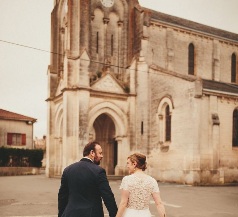 Lace detail Sarah Seven wedding dress with groom at French wedding venue