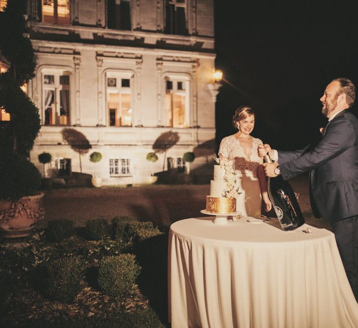 Bride and groom cut the white and gold wedding cake