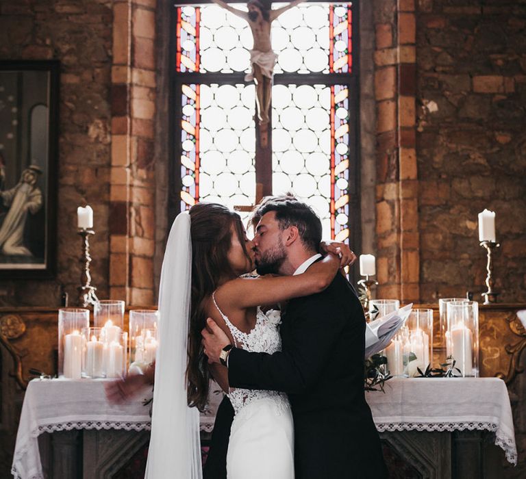 Bride and groom kiss after vows at black and white wedding