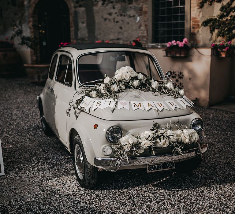 Fiat 500 wedding car decorated with flowers and bunting