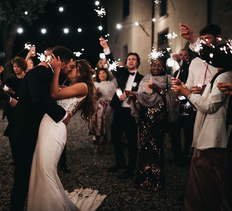 Guests wave sparklers for bride and grooms first dance